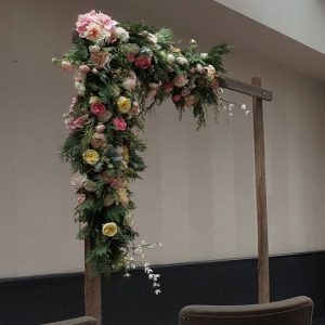 wooden wedding arbour with pink flowers